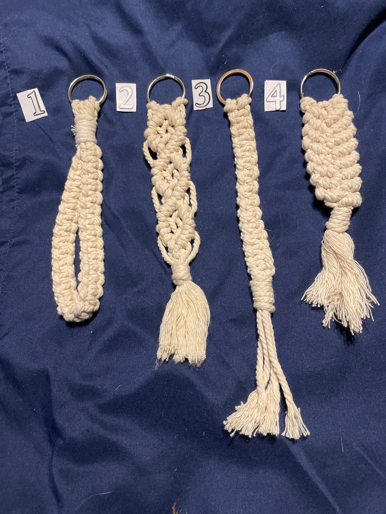 May include: Four handmade macrame keychains with different patterns and a tassel at the bottom. The keychains are numbered 1 through 4.