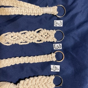 May include: Four macrame keychains with different patterns and a silver key ring. The keychains are numbered 1 through 4.
