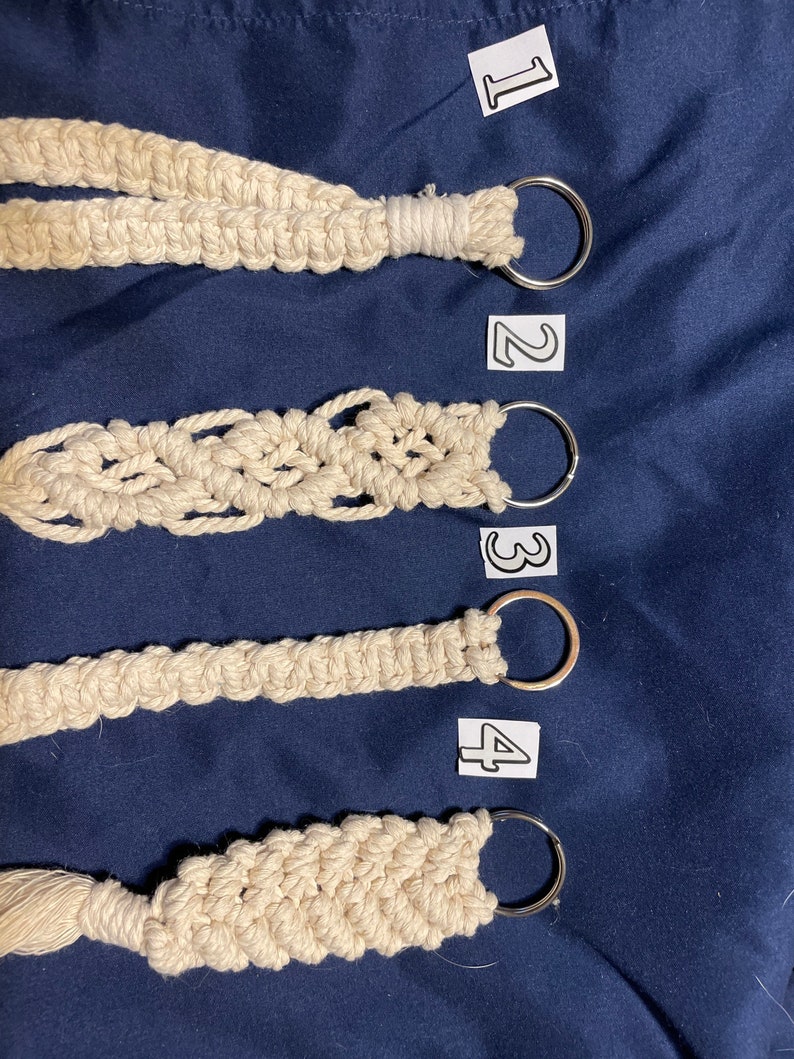 May include: Four macrame keychains with different patterns and a silver key ring. The keychains are numbered 1 through 4.