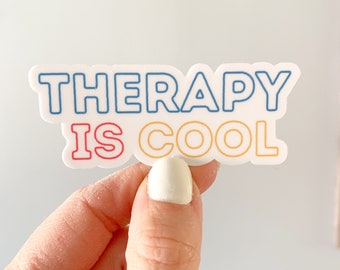 May include: A white sticker with the text "THERAPY IS COOL" in colorful outlined letters. The letters are outlined in blue, red, and yellow.