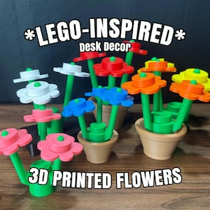 May include: A collection of 3D printed flowers in various colors including red, orange, yellow, blue, pink, and white, featuring green stems and small tan pots. The text *LEGO-INSPIRED* Desk Decor and 3D PRINTED FLOWERS is visible in the image.