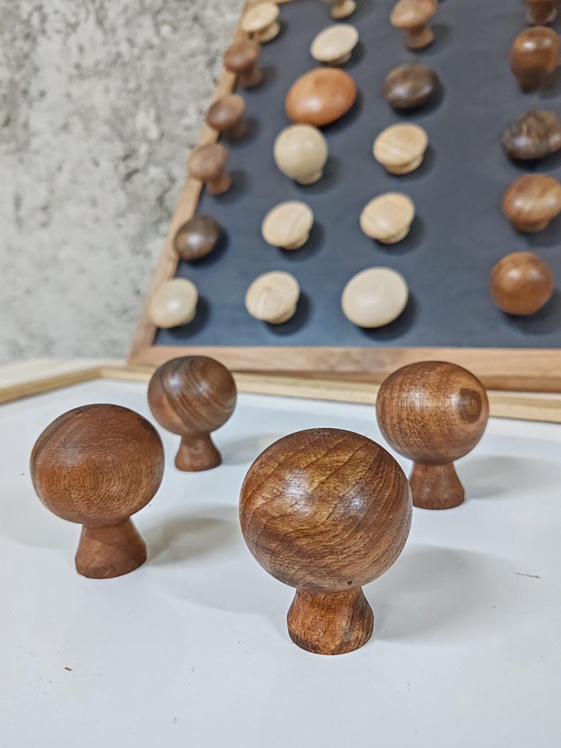 May include: Four wooden knobs with a round top and a short stem. The knobs are made of dark brown wood and have a smooth finish.