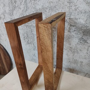 Puede incluir: Dos patas de mesa de madera, te&ntilde;idas de un color marr&oacute;n intenso, est&aacute;n hechas de madera gruesa y resistente. Las patas son de forma rectangular y tienen un dise&ntilde;o simple y moderno.