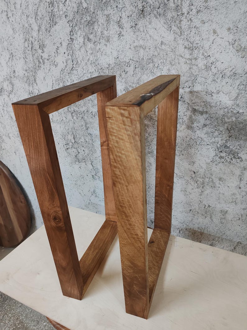 Puede incluir: Dos patas de mesa de madera, te&ntilde;idas de un color marr&oacute;n intenso, est&aacute;n hechas de madera gruesa y resistente. Las patas son de forma rectangular y tienen un dise&ntilde;o simple y moderno.