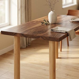 May include: A rectangular wooden dining table with a dark brown top and light brown legs. A white vase with branches and a linen napkin are on the table. The table is 72 inches long.