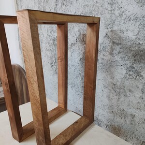 Puede incluir: Dos patas de mesa de madera con un acabado de madera natural. Las patas son cuadradas y tienen un dise&ntilde;o sencillo.