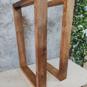 Puede incluir: Dos patas de mesa de madera en forma de marco rectangular. Las patas son de color marr&oacute;n oscuro y tienen una veta de madera natural.