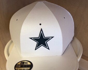 May include: White baseball cap with a black star and the text "59FIFTY" in gold on a black sticker. The sticker also has the text "Fly Your Own Flag".