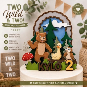 May include: A layered cardstock cake topper featuring a brown bear, a yellow duck, and a brown owl in a forest setting with a red mushroom. The text reads TWO WILD & TWO, KYLO, and the number 2. The design includes green trees and a blue sky.