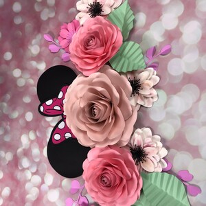 May include: A pink and white paper flower arrangement with a black and red Minnie Mouse bow. The flowers are layered and have a 3D effect.