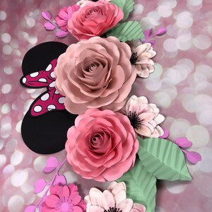 May include: A paper flower arrangement featuring pink and white roses, pink and purple flowers, and green leaves. The arrangement includes a black and red paper Mickey Mouse ears.