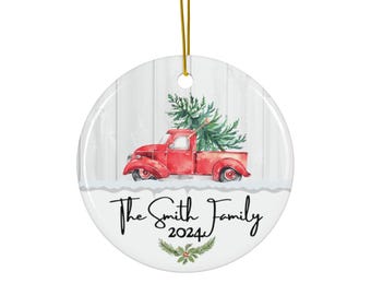 May include: A red truck with a Christmas tree in the bed, on a white wood background. The text "The Smith Family 2024" is below the truck.