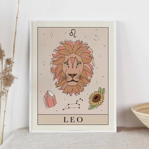 May include: A beige and peach colored illustration of the Leo zodiac sign. The illustration features a lion's head with a sunflower, a crystal, and a constellation in the background. The text "LEO" is written below the lion's head.
