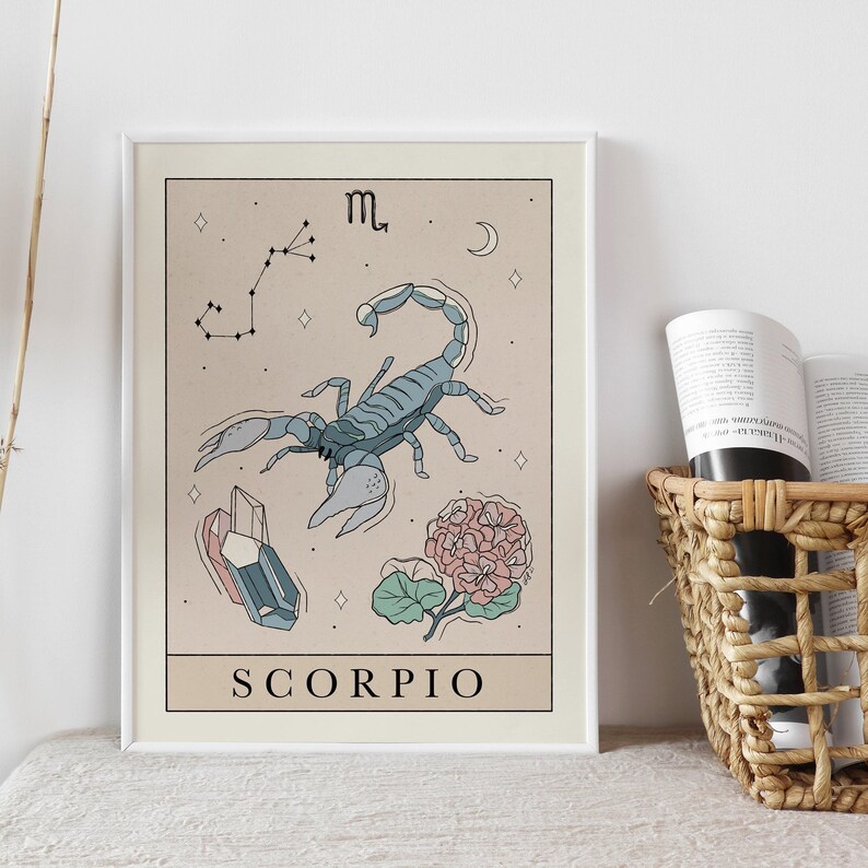 Pu&ograve; includere: Una stampa incorniciata beige e bianca con un'illustrazione di scorpione blu, una costellazione e un fiore rosa. Il testo "SCORPIO" &egrave; in fondo alla stampa.