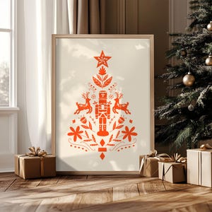 May include: A framed print featuring a festive Christmas tree design. The tree is composed of orange illustrations of a star, deer, a nutcracker, and floral elements on a cream background. The print is displayed near a Christmas tree and wrapped gifts.