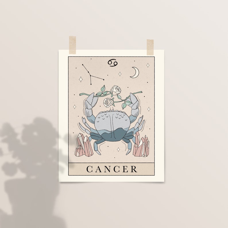 May include: A beige illustrated poster with a blue crab, a constellation, a crescent moon, and white roses. The poster has the text "CANCER" at the bottom.