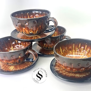 May include: A white ceramic mug with a black handle and the text "But First, Coffee" in a handwritten style. The mug is on a white surface. The mug is 4 inches tall.