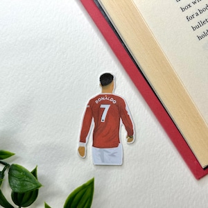 Puede incluir: Una camiseta de fútbol roja y blanca con el nombre "RONALDO" y el número "7" en la espalda.