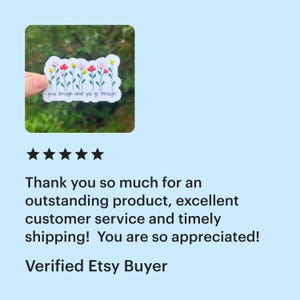 A five-star review of the go through what you go through sticker from a verified Etsy buyer. The review says "thank you so much for an outstanding product, excellent customer service and timely shipping! You are so appreciated!" The product thumbnail shows a glossy white sticker with a row of yellow, pink, and red flowers with green stems. The text below the flowers reads "grow through what you go through" in black text.