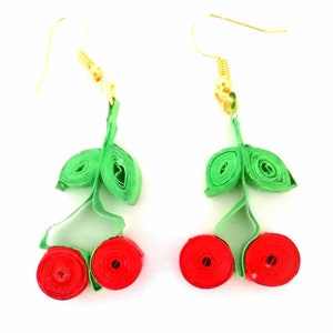 Pode incluir: Um par de brincos de cereja feitos com papel de quilling verde e vermelho. Os brincos têm ganchos dourados.