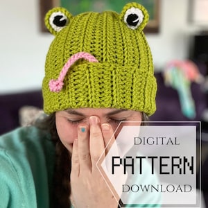 May include: A crochet pattern for a green frog hat with pink tongue and black eyes. The pattern is available for digital download. DIGITAL PATTERN DOWNLOAD.