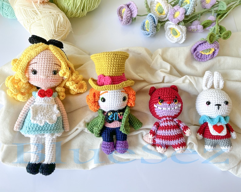 May include: A set of five crocheted stuffed toys, including Alice in Wonderland, the Mad Hatter, the Cheshire Cat, and the White Rabbit. The toys are all handmade and feature intricate details.