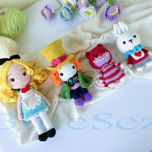 May include: Four crocheted stuffed toys inspired by Alice in Wonderland: Alice, the Mad Hatter, the Cheshire Cat, and the White Rabbit. The toys are all handmade and feature detailed features, such as Alice's blue dress and the Mad Hatter's top hat.
