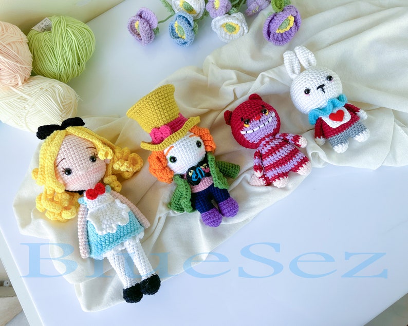 May include: Four crocheted stuffed toys inspired by Alice in Wonderland: Alice, the Mad Hatter, the Cheshire Cat, and the White Rabbit. The toys are all handmade and feature detailed features, such as Alice's blue dress and the Mad Hatter's top hat.