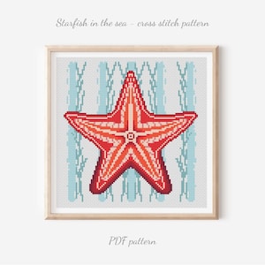May include: Cross-stitch pattern featuring a red and orange starfish against a light blue and white striped backdrop, framed in light wood. The text at the top says "Starfish in the sea - cross stitch pattern" and at the bottom "PDF pattern".