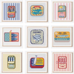May include: Nine framed art prints displaying vintage-style sardine can illustrations. Each print presents a unique sardine can design with diverse colours and backgrounds, including stripes and solid colours. The cans are illustrated in a retro style.