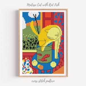 May include: A framed cross-stitch pattern of a yellow cat reaching into a fishbowl with two red fish. The artwork is inspired by Matisse, with a colorful, geometric design. The text "Matisse Cat with Red Fish" and "cross stitch pattern" are visible.