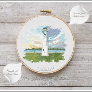 Peut inclure: Motif de point de croix d'un phare blanc avec un toit vert sur fond de ciel bleu avec des nuages. Le phare est situ&eacute; sur une petite &icirc;le avec de l'herbe verte et des arbres. Le texte "Peche Island Rear Range Light in Marine City" est situ&eacute; sous l'image.