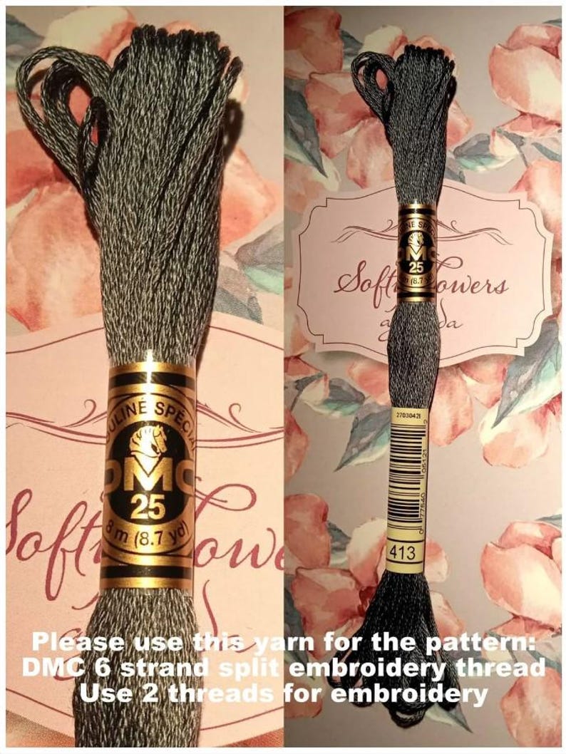 May include: A skein of DMC 25 embroidery floss in color 413, a dark gray. The label indicates 8.7 yards of thread. The text on the image says to use this yarn for the pattern, DMC 6 strand split embroidery thread, using 2 threads for embroidery.