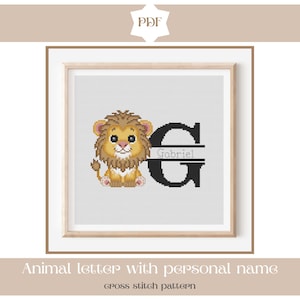 Puede incluir: Un patrón de punto de cruz enmarcado con un león de dibujos animados y la letra "G" con el nombre "Gabriel". El león es de color amarillo y marrón. El texto "Animal letter with personal name" y "cross stitch pattern" está en la parte inferior.