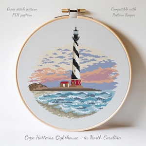 May include: A cross-stitch pattern of the Cape Hatteras Lighthouse in North Carolina, featuring a black and white striped tower, a red-roofed building, and ocean waves. The design is set against a sunset sky and is compatible with Pattern Keeper.