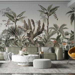 May include: A modern living room with a tropical mural, a gray sofa, and a marble coffee table. The room features a mustard-colored accent chair, a patterned ottoman, and a large cactus art piece. A floor lamp provides additional lighting.