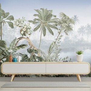 May include: A white media console with a wood top and legs sits in front of a tropical jungle mural. The mural features palm trees, lush foliage, and a blue lake in the background.