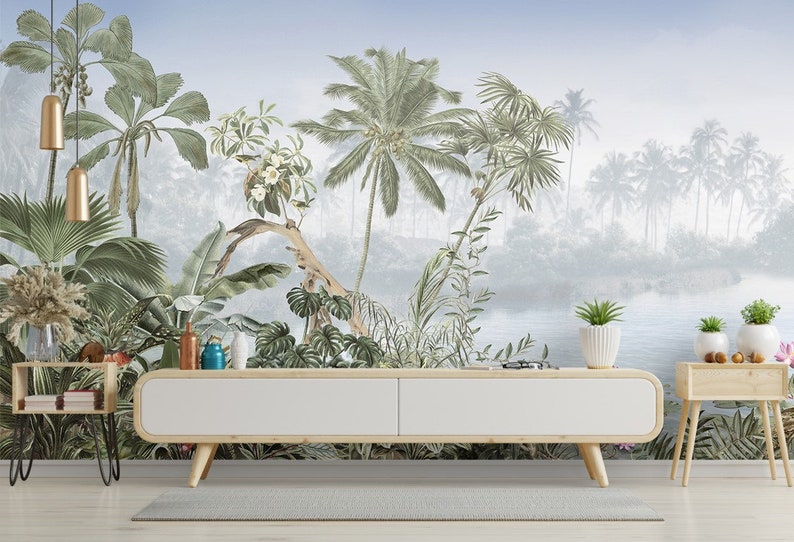May include: A white media console with a wood top and legs sits in front of a tropical jungle mural. The mural features palm trees, lush foliage, and a blue lake in the background.