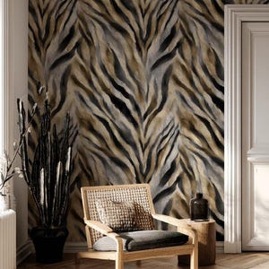 Op de afbeelding: Een kamer met een tijgerstreep behang in bruin, grijs en zwart. Een houten stoel met een geweven rugleuning en een grijs kussen staat voor de muur. Een zwarte potplant en een kleine houten bijzettafel zijn ook aanwezig.