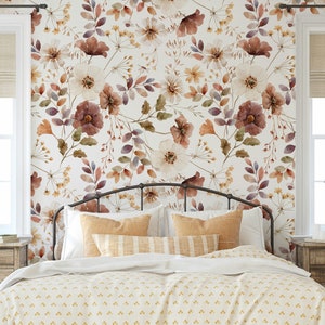 Puede incluir: Un dormitorio con una cama blanca con un edred&oacute;n estampado floral y una cabecera. La pared detr&aacute;s de la cama tiene un papel tapiz floral con un dise&ntilde;o de acuarela en tonos marrones, blancos y morados.