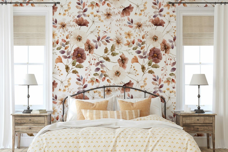 Puede incluir: Un dormitorio con una cama blanca con un edred&oacute;n estampado floral y una cabecera. La pared detr&aacute;s de la cama tiene un papel tapiz floral con un dise&ntilde;o de acuarela en tonos marrones, blancos y morados.