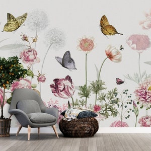 May include: A floral wallpaper mural with a gray armchair and a woven ottoman in front of it. The wallpaper features pink, white, and green flowers, as well as butterflies.