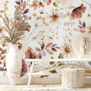 Puede incluir: Un banco blanco con una cesta de mimbre blanca delante. La pared detr&aacute;s del banco est&aacute; decorada con un papel tapiz floral de acuarela con flores marrones, blancas y moradas.
