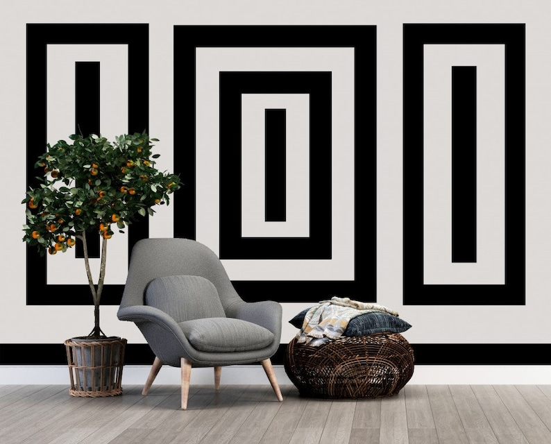 Puede incluir: Un sill&oacute;n gris con patas de madera se encuentra frente a una pared blanca con un patr&oacute;n geom&eacute;trico en blanco y negro. Un peque&ntilde;o &aacute;rbol de naranja en maceta se encuentra a la izquierda del sill&oacute;n. Una cesta tejida con una manta de lana gris y blanca se encuentra frente al sill&oacute;n.