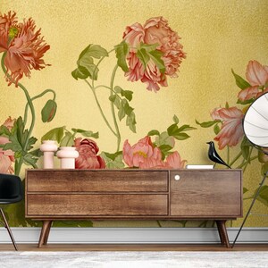 May include: A floral wallpaper mural with a yellow background and pink and red flowers. The wallpaper is displayed in a room with a wooden dresser and a black chair.