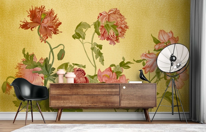 May include: A floral wallpaper mural with a yellow background and pink and red flowers. The wallpaper is displayed in a room with a wooden dresser and a black chair.