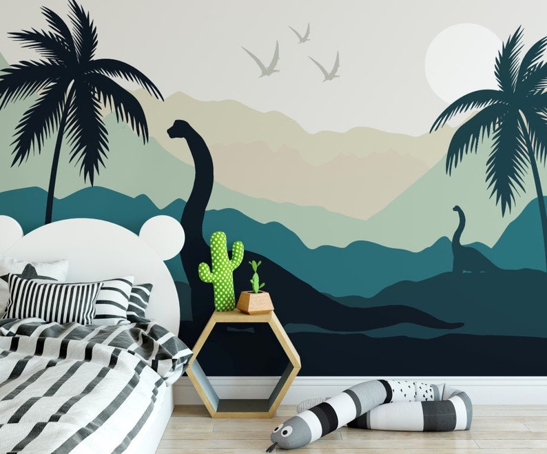 Puede incluir: Una cordillera azul y verde con dos dinosaurios y palmeras. La escena est&aacute; pintada en una pared detr&aacute;s de una cama blanca con ropa de cama a rayas blancas y negras.