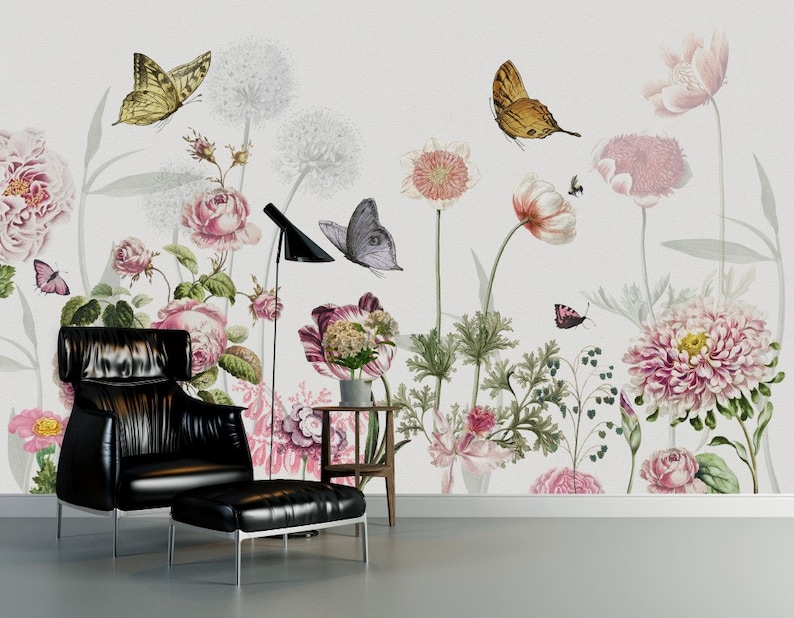 May include: A black leather armchair with a matching ottoman sits in front of a wall mural featuring a floral design with butterflies. The mural features pink, white, and green flowers with brown butterflies.