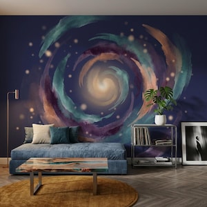 Peut inclure: Un salon avec un canapé bleu, des coussins, une table basse en bois et un tapis rond. Le mur est orné d'une peinture murale sur le thème de la galaxie dans des tons de bleu, de violet et d'orange. Un lampadaire, des étagères métalliques avec une plante et des œuvres d'art encadrées complètent le décor.