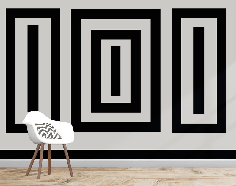 Puede incluir: Tres cuadrados negros enmarcados con l&iacute;neas negras conc&eacute;ntricas en una pared blanca. Los cuadrados est&aacute;n dispuestos en una fila. Una silla blanca con un coj&iacute;n de patr&oacute;n blanco y negro se encuentra frente a la pared.